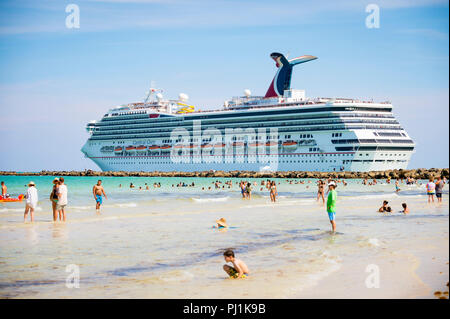 MIAMI - circa 2018, juin : Carnival Glory croisière navire quitte le port et passe les gens patauger dans les eaux peu profondes de la Plage du Sud. Banque D'Images