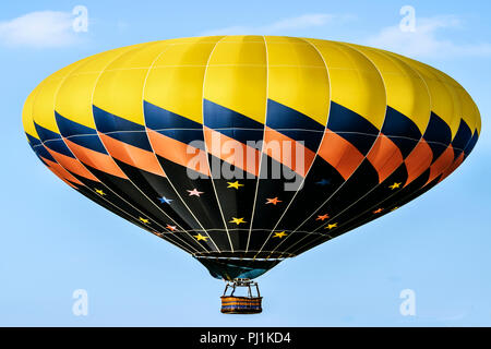 Jaune et Noir hot air balloon dans l'air Banque D'Images
