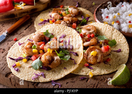 De délicieux tacos de crevettes épicées avec sriracha mayo sur une table en bois rustique. Banque D'Images
