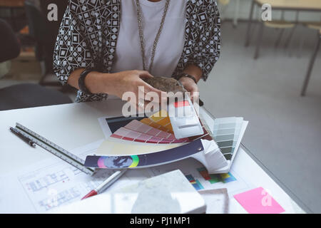 Femme de couleur contrôle exécutif sur table à dessin Banque D'Images