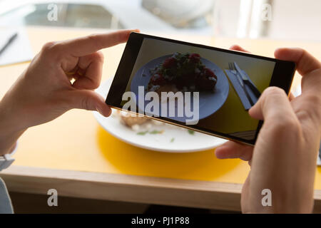 Woman taking photo d'aliments sur la plaque au café Banque D'Images
