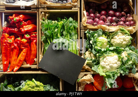 Des légumes frais dans des caisses en bois vides avec étiquette de prix, l'affichage du marché Banque D'Images