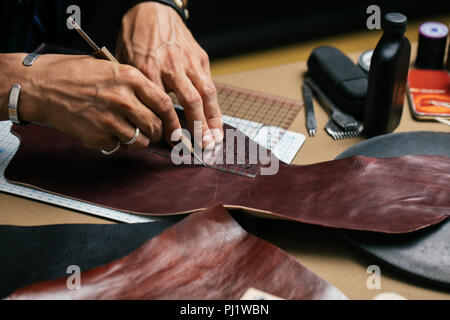 Close up of skinner artisan travaillant avec l'aide d'outils d'artisanat en cuir naturel. Banque D'Images