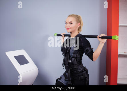 Super femme sportive en costume et EMS stick pose à l'appareil photo Banque D'Images