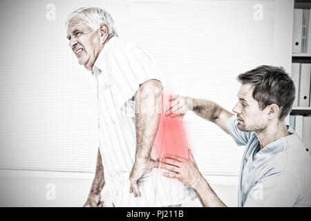 Image composite d'hommes physiotherapist examining senior mans retour Banque D'Images