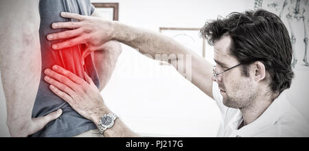 Composite image d'un mâle physiotherapist examining mans retour Banque D'Images