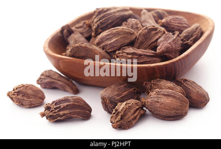 Cardamome noire dans un bol en bois sur fond blanc Banque D'Images