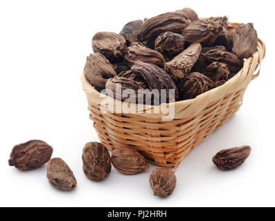 Cardamome noire dans un panier sur fond blanc Banque D'Images