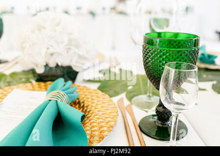 L'intérieur de tente pour diner de mariage, prêts pour les clients. Servi en plein air table de banquet ronde décorée de renom dans l'hydrangea fleurs, des plats d'or et vert. Concept de restauration Banque D'Images