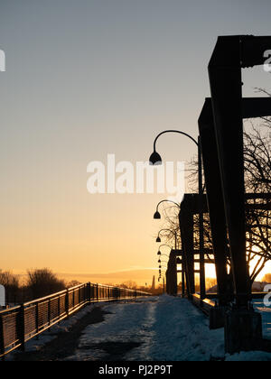 Une rangée de structures métalliques au Vieux Port ou Vieux Port de Montréal Québec, Canada. Photographié au lever du soleil dans l'hiver avec des arbres sans feuilles dans la b Banque D'Images