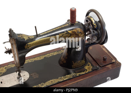 Machine à coudre à la main vintage au travail. Le volant moteur arrière est flou en raison de la rotation de la roue, isolé sur fond blanc avec clipping path Banque D'Images