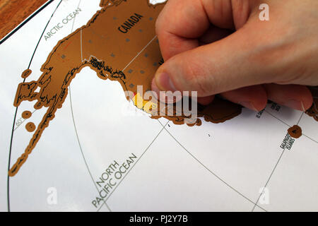 La main de l'homme pour gratter a visité les lieux sur une carte. Les voyages aux États-Unis. Un concept des destinations de voyage Banque D'Images