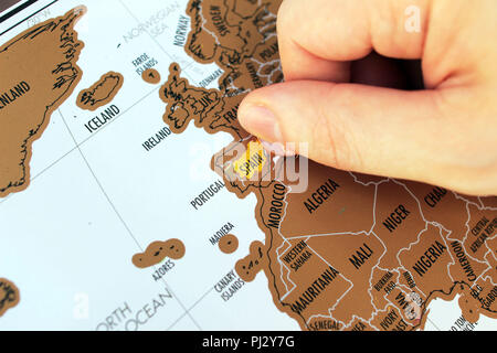 La main de l'homme pour gratter a visité les lieux sur une carte. Billet d'Europe. Un concept des destinations de voyage Banque D'Images