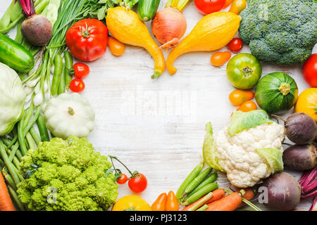 Les produits agricoles frais, cadre coloré fait de légumes biologiques et des herbes sur fond de bois blanc, en bonne santé, l'arrière-plan de l'espace pour copier du texte dans le milieu, vue du dessus, selective focus Banque D'Images