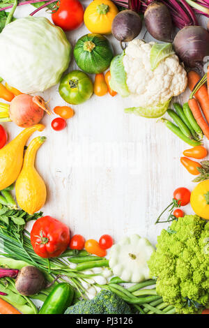 Les produits agricoles frais, cadre coloré fait de légumes biologiques et des herbes sur fond de bois blanc, en bonne santé, l'arrière-plan de l'espace pour copier du texte dans le milieu, vue du dessus, selective focus Banque D'Images