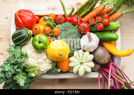 Les légumes frais biologiques dans un bac blanc en bois sur table en pin, vue du dessus, selective focus Banque D'Images