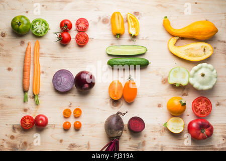 Une cuisine créative dans une grille de fond, assortiment de légumes bio coloré ensemble et couper la partie en bois sur table en pin, vertical, vue de dessus, selective focus Banque D'Images