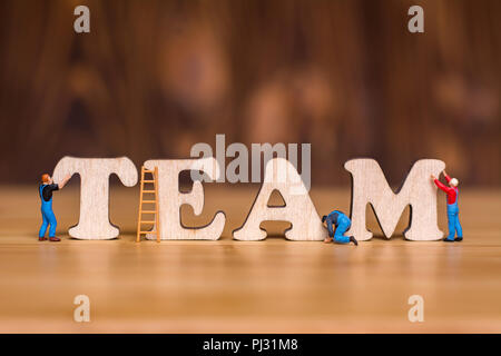 Concept créatif à propos d'équipe. Les gens de lettres en bois miniatures et de l'équipe. Le nombre de travailleurs. Banque D'Images