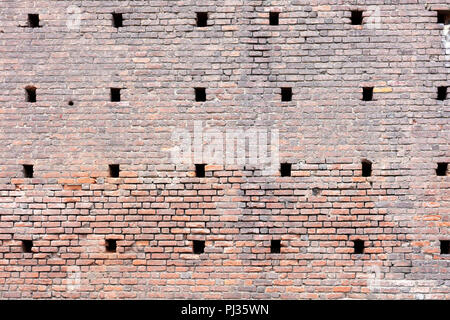 Mur de briques d'adobe rouge arrière-plan, avec les trous de ventilation situés dans le château Sforza Banque D'Images