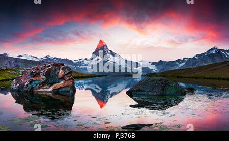 Été haut en couleurs le lever de soleil sur le lac Stellisee. Reflet de Matterhorn (Monte Cervino, Mont Cervin) sommet de l'eau surface. Belle piscine sce Banque D'Images