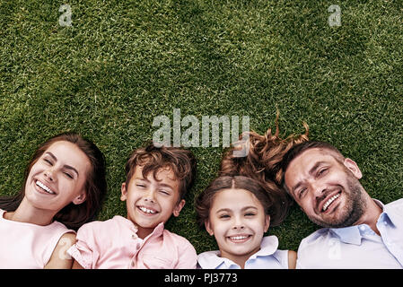 Portrait de bonheur. Famille de quatre personnes se trouvant sur les champs smiling Banque D'Images