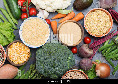 Dans ofrains divers bols et légumes, brocoli, courge, haricots, tomates, carottes, avocat, quinoa, pois, riz, avoine, selective focus Banque D'Images