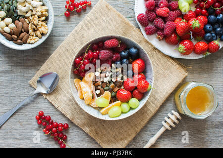Vue aérienne de céréales muesli fait de paleo avec fruits secs, servi avec des fraises, bleuets, framboises, groseilles, raisin, se Banque D'Images