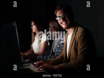 Homme d'affaires travaillant à l'ordinateur à l'office de nuit. Banque D'Images