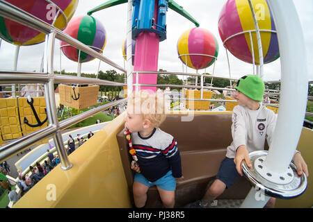 Deux garçons âgés de 2 et 9 ans sur Peppa Pig's big balloon ride, Peppa pig world, Paultons Park , Romsey, Hampshire, Angleterre, Royaume-Uni. Banque D'Images