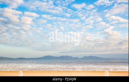 Avis de Yr Eifl montagne à partir de la plage de sable UK vide Ynys Llanddwyn (île de marée, Anglesey, Pays de Galles). Ciel bleu spectaculaire et filandreux, cumulus. Banque D'Images