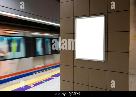 Un seul grand vertical / orientation portrait blank billboard dans les transports publics avec l'arrière-plan de la plate-forme de métro Banque D'Images