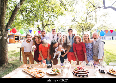 Fête de famille à l'extérieur dans la cour. Big garden party. Fête d'anniversaire. Famille qui pose pour la photo. Banque D'Images