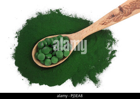 Poudre d'algue spiruline en comprimés et cuillère en bois isolé sur fond blanc. Vue d'en haut. Banque D'Images