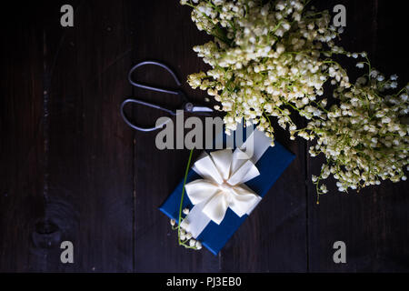 Concept floral printemps avec bouquet de fleurs lys mai et vintage clippers sur fond de bois Banque D'Images