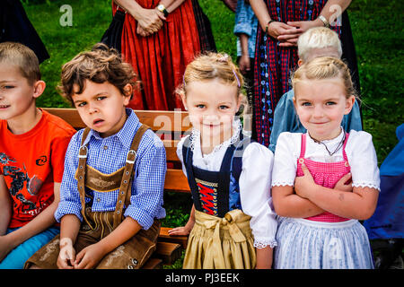 Les enfants en costume traditionnel tyrolien de pantalons pour les garçons et pour les filles du dirndl assister à jour de favoritisme à Reith bei Seefeld, Autriche Banque D'Images