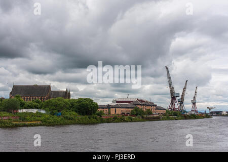 Glasgow, Scotland, UK - 17 juin 2012 : le long de la rivière Clyde et du port, les grues et les toits de l'entrepôt avec Govan ancienne église paroissiale à gauche. Gris foncé Banque D'Images