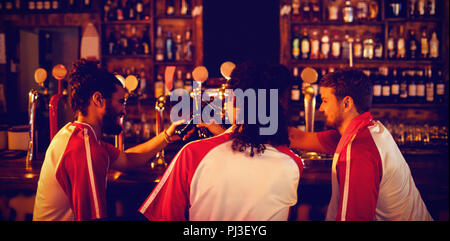 Groupe d'amis masculins toasting beer bottles Banque D'Images