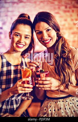 Portrait de deux jeunes femmes ayant des cocktails Banque D'Images