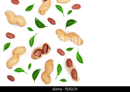 Les arachides avec des coquilles décorées avec des feuilles vert isolé sur fond blanc avec l'exemplaire de l'espace pour votre texte, vue d'en haut Banque D'Images
