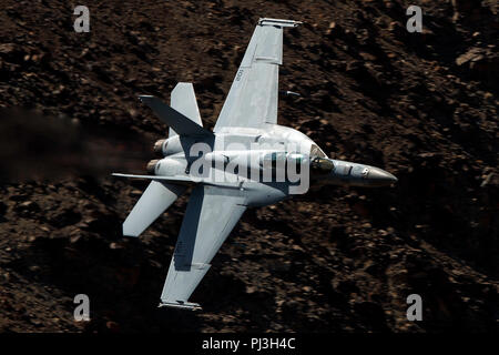 United States Navy Boeing F/A-18F Super Hornet (102) côté de la VFA-154 Black Knights squadron vole bas niveau sur la transition par Star Wars Jedi Canyon / Rainbow Canyon, Death Valley National Park, Panamint Springs, California, United States of America Banque D'Images