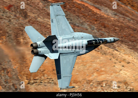 United States Navy Boeing F/A-18F Super Hornet (102) côté de la VFA-154 Black Knights squadron vole bas niveau sur la transition par Star Wars Jedi Canyon / Rainbow Canyon, Death Valley National Park, Panamint Springs, California, United States of America Banque D'Images
