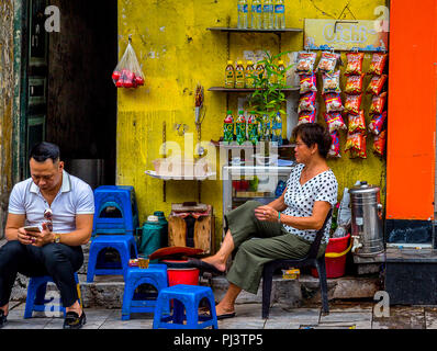L'alimentation de rue à Hanoi est un peu différent. Les sections locales, à l'extérieur de leur porte, accrocher les croustilles, boissons, et cuire juste là. Banque D'Images