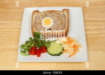 Le porc et l'oeuf salade parmentier de gala sur une plaque sur une table en bois Banque D'Images