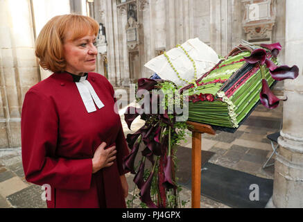 Le très révérend Catherine Ogle, Doyen de la cathédrale de Winchester, regarde une bible en fleurs pendant un photocall pour la cathédrale de Winchester's fête des fleurs, de l'éclairage : un festival de fleurs, qui se déroule du 5 au 9 septembre. Banque D'Images