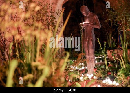 Ligne de fleurs et de bougies d'un itinéraire vers la statue 'Sound II' par Antony Gormley dans la crypte de la cathédrale de Winchester que les derniers préparatifs sont faits pour s'affiche pour leur fête des fleurs, de l'éclairage : un festival de fleurs, qui se déroule du 5 au 9 septembre. Banque D'Images