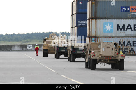 Employés avec le terminal à conteneurs en eaux profondes de route des véhicules militaires à une aire de rassemblement désigné, pour le 2e Escadron, 278e régiment de cavalerie blindée, une unité de la Garde nationale basée à Knoxville, Tennessee, dans le port de Gdansk, Pologne, le 28 août. La Pologne est l'un des quatre nations-cadre de l'OTAN pour l'amélioration de l'avant, la présence de l'Atlantique, une opération de résoudre la mission de formation de neuf mois pour réserver, Garde nationale et les unités de service actif avec les partenaires de l'OTAN dans l'engagement pour la paix, la sécurité et la stabilité en Europe. Banque D'Images
