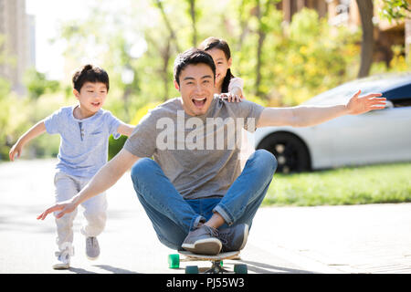 Happy young family Playing with skateboard Banque D'Images