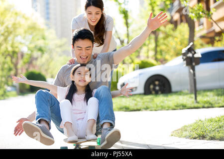 Happy young family Playing with skateboard Banque D'Images