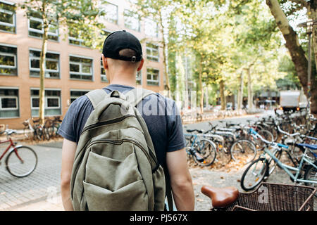 Un étudiant avec un sac à dos ou un touriste sur la rue de Leipzig en Allemagne près de la location d'un parking, à côté de la bibliothèque de l'Université de Leipig et student hostel. Banque D'Images