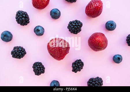 Mise à plat de fruits rouges sur fond de couleur pastel. Banque D'Images